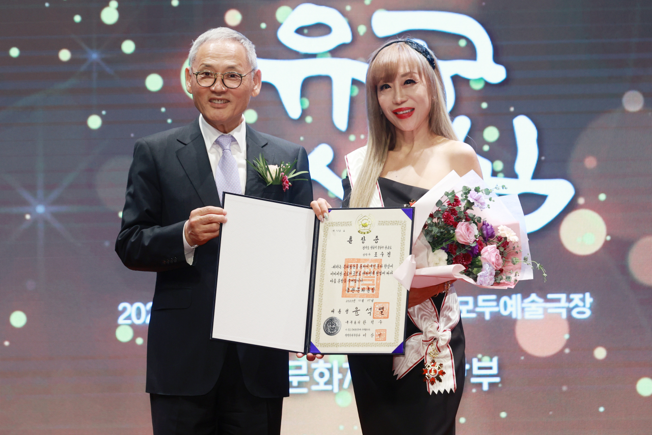 Soprano Sumi Jo (right) and Culture Minister Yoo In-chon pose for a photo at a ceremony recognizing contributions in the field of culture and arts, in Seoul, Friday. (Yonhap)