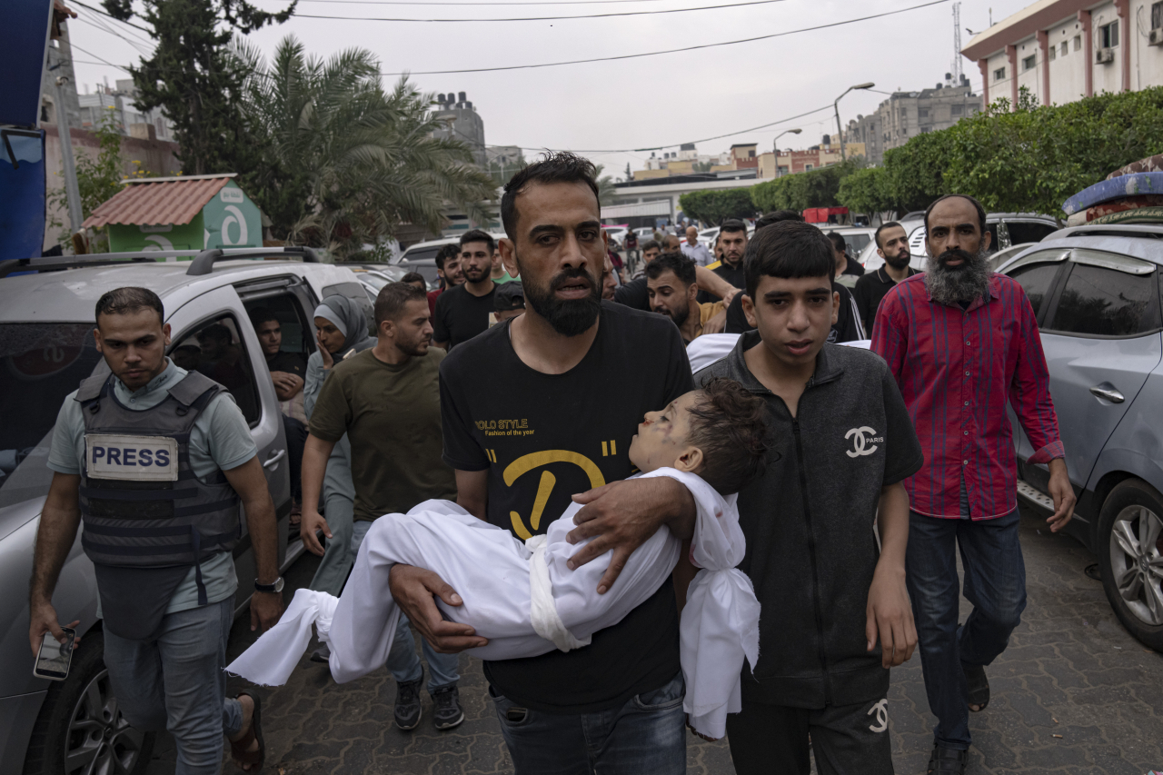 Palestinian mourners carry the body of their relatives killed in the Israeli bombardment of the Gaza Strip, in Khan Younis, Sunday. (AP-Yonhap)
