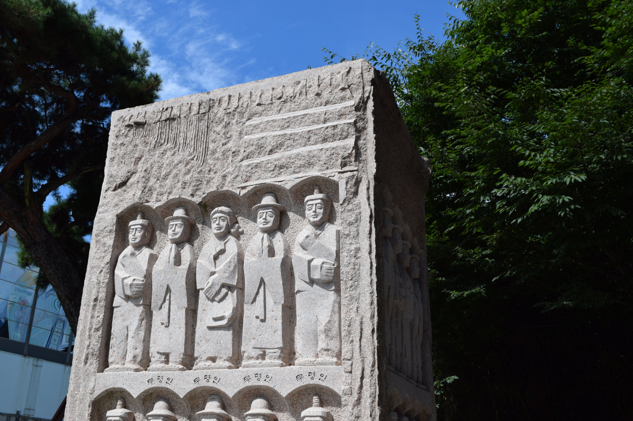 A stone engraved with figures in memory of Catholic believers who were martyred during the persecutions of 1866 (Kim Hae-yeon/ The Korea Herald)