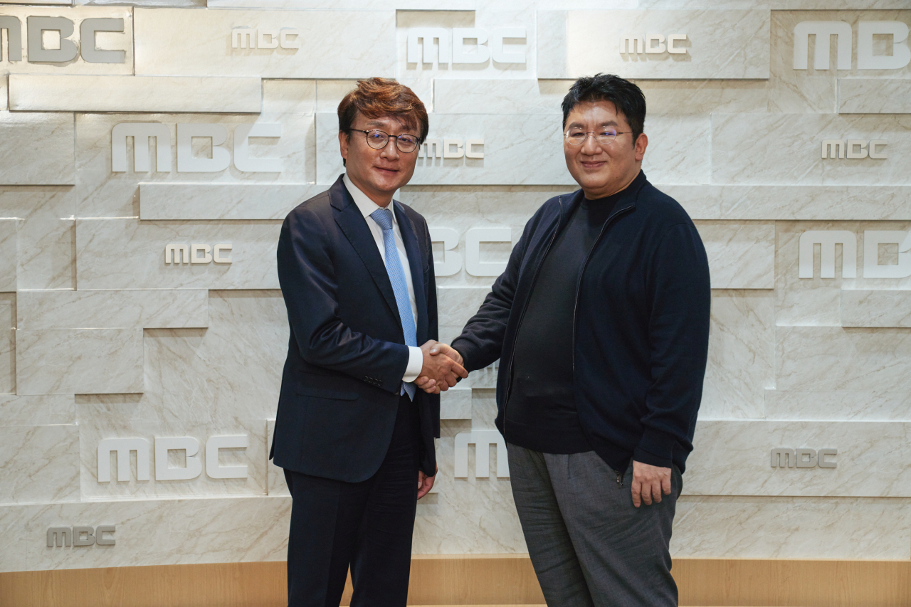 MBC President Ahn Hyung-joon (left) and Hybe chairman Bang Si-hyuk pose for photos at MBC headquarters in Sangam-dong, western Seoul, Monday. (MBC)