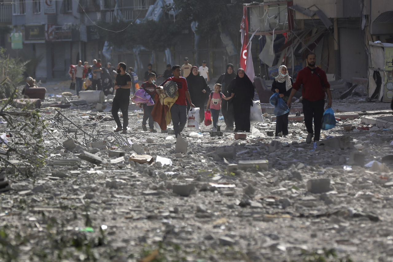 Palestinians leave their homes following Israeli bombardment on Gaza City, Monday. (AP-Yonhap)