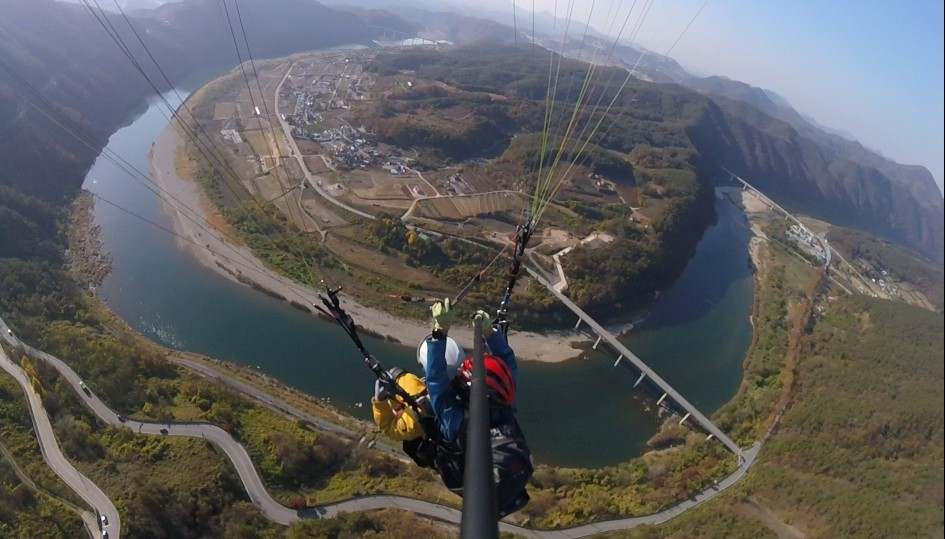 The Korea Herald reporter paraglides with Parastory pilot at Danyang, North Chungcheong Province on Thursday. (Lee Si-jin/The Korea Herald)