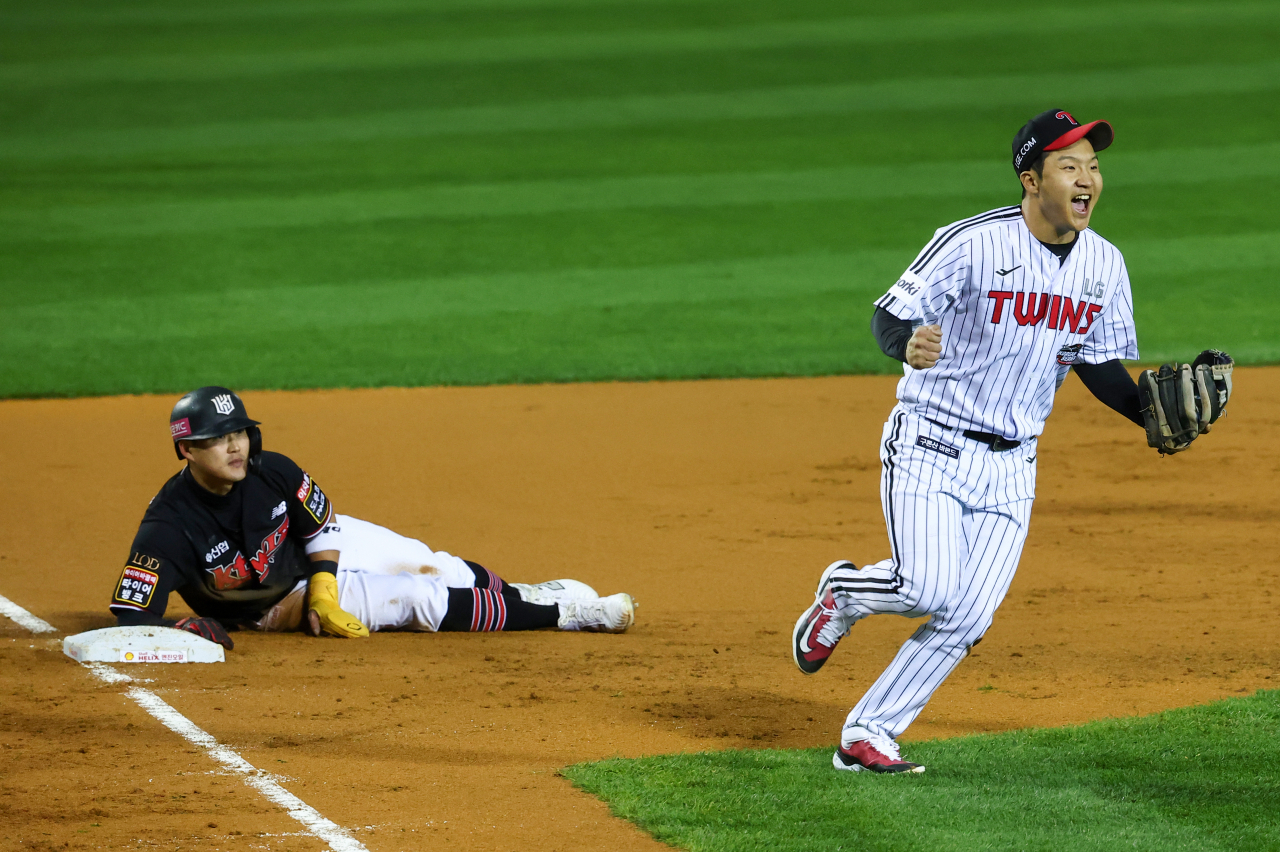 LG Twins third baseman Moon Bo-gyeong (left) reacts after tagging out Mun Sang-cheol of the KT Wiz at third base during the Korean Series at Jamsil Baseball Stadium in Seoul, on Tuesday. (Yonhap)