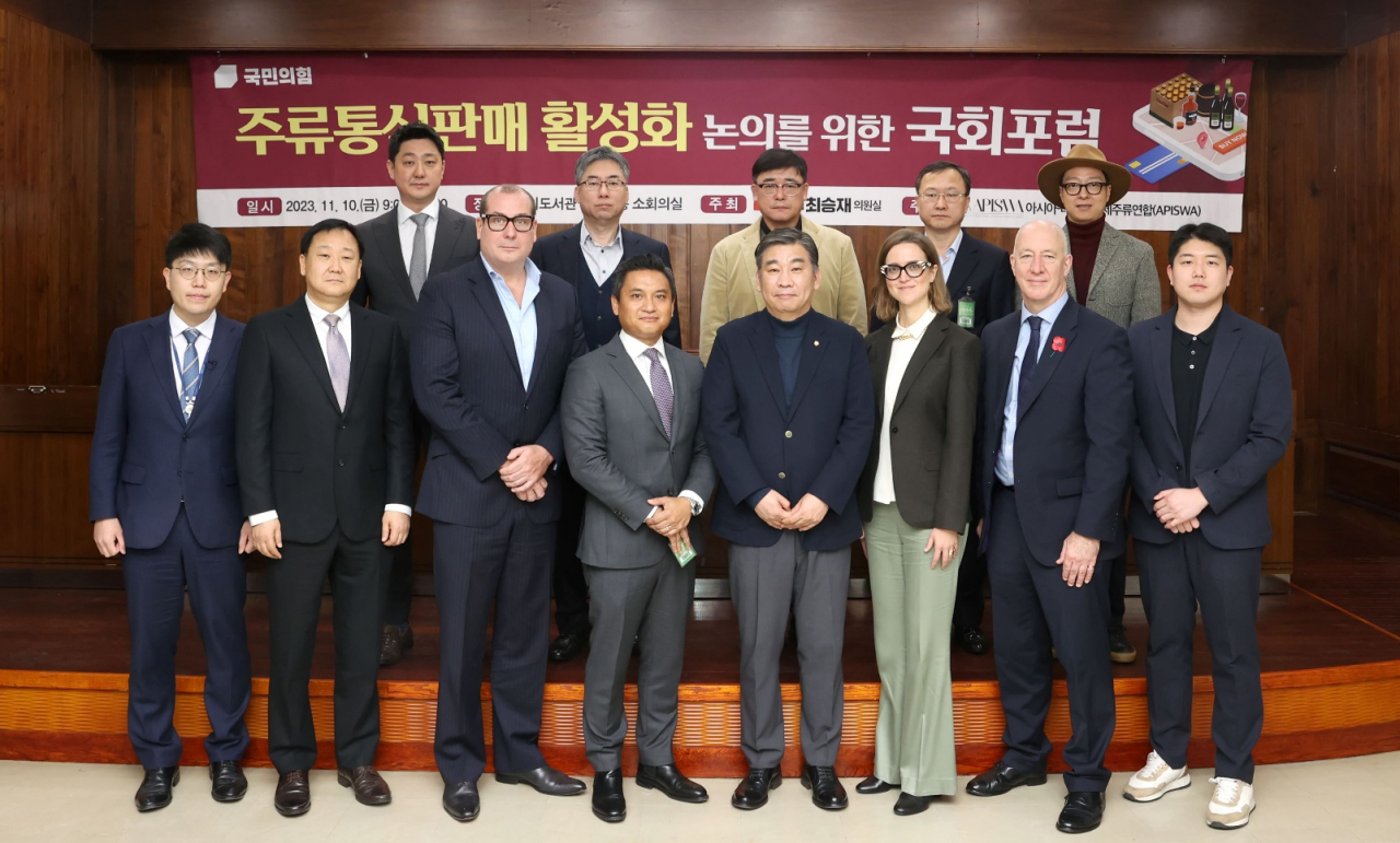Rep. Choi Seung-Jae of the People Power Party (center right) and Asia Pacific International Spirts and Wines Alliance Chair Vijay S. Subramaniam (center left) are pictured with forum participants at the “National Assembly Discussion Forum on Invigorating E-Commerce”, held at the National Assembly Library in Seoul on Friday.