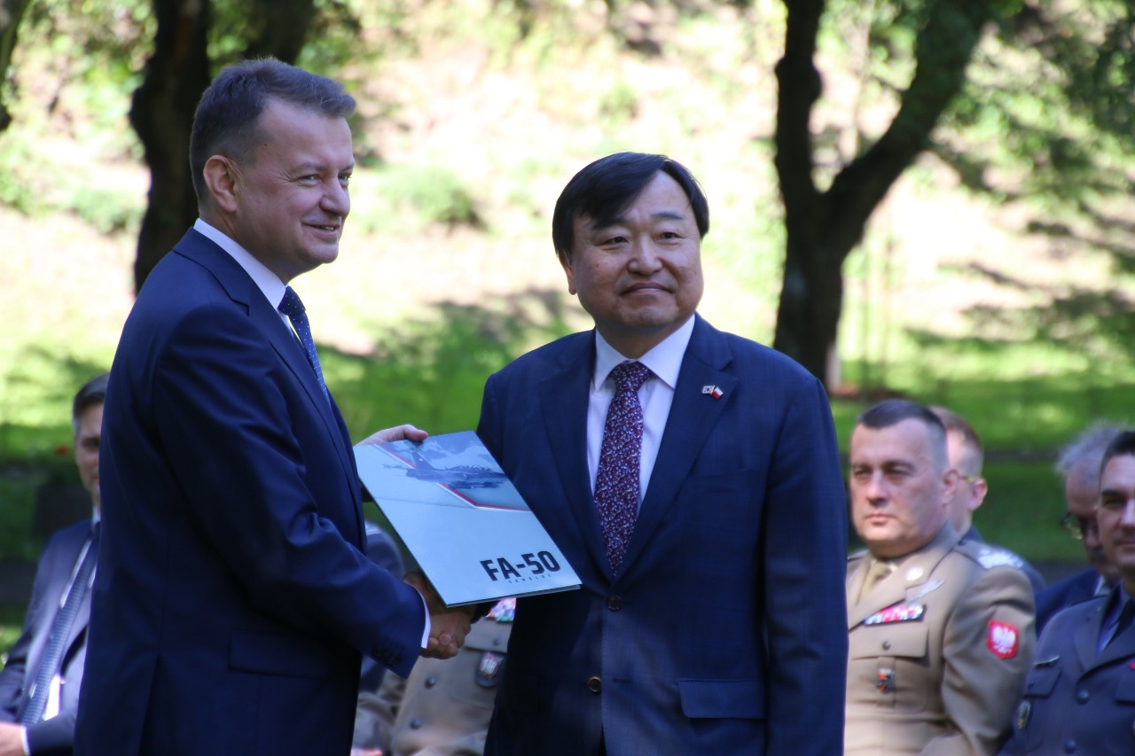 Polish Deputy Prime Minister and Defense Minister Mariusz Blaszczak (left) and Korea Aerospace Industries CEO Ahn Hyun-ho pose for a photo after signing a contract to purchase South Korean arms in Warsaw, Poland, in 2022. (Joint press corps of the Defense Ministry)