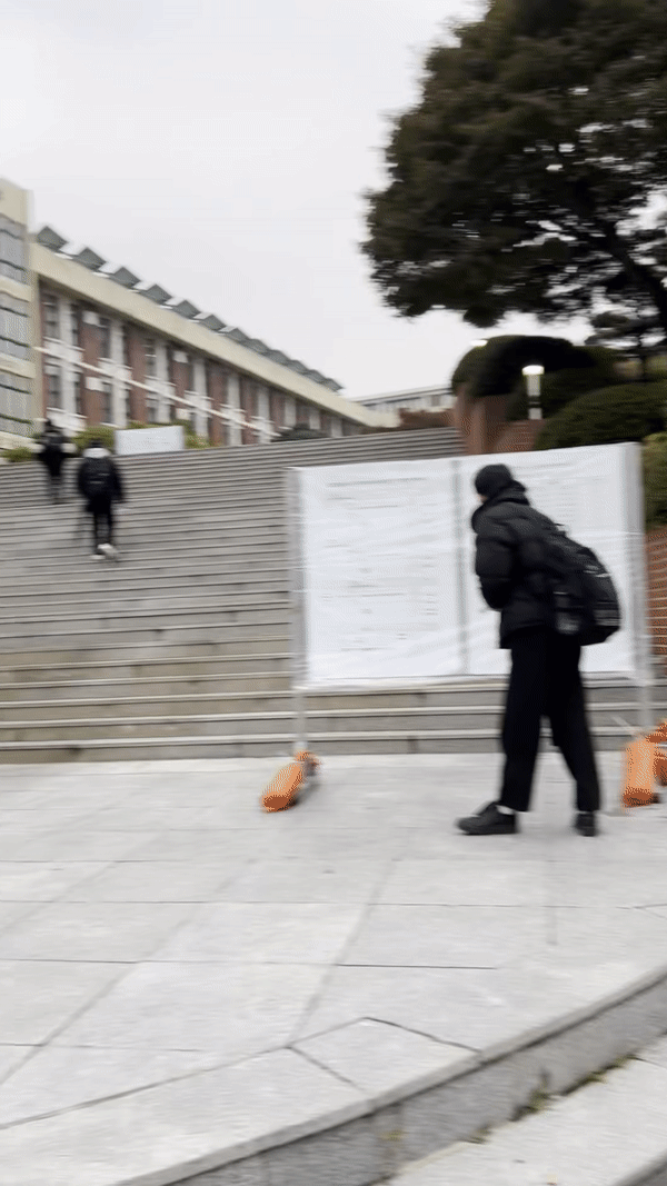 Students go up the stairs in front of Dongsung High School in Jongno, central Seoul, as they attend the Suneung exam, Thursday. (Park Jun-hee/The Korea Herald)