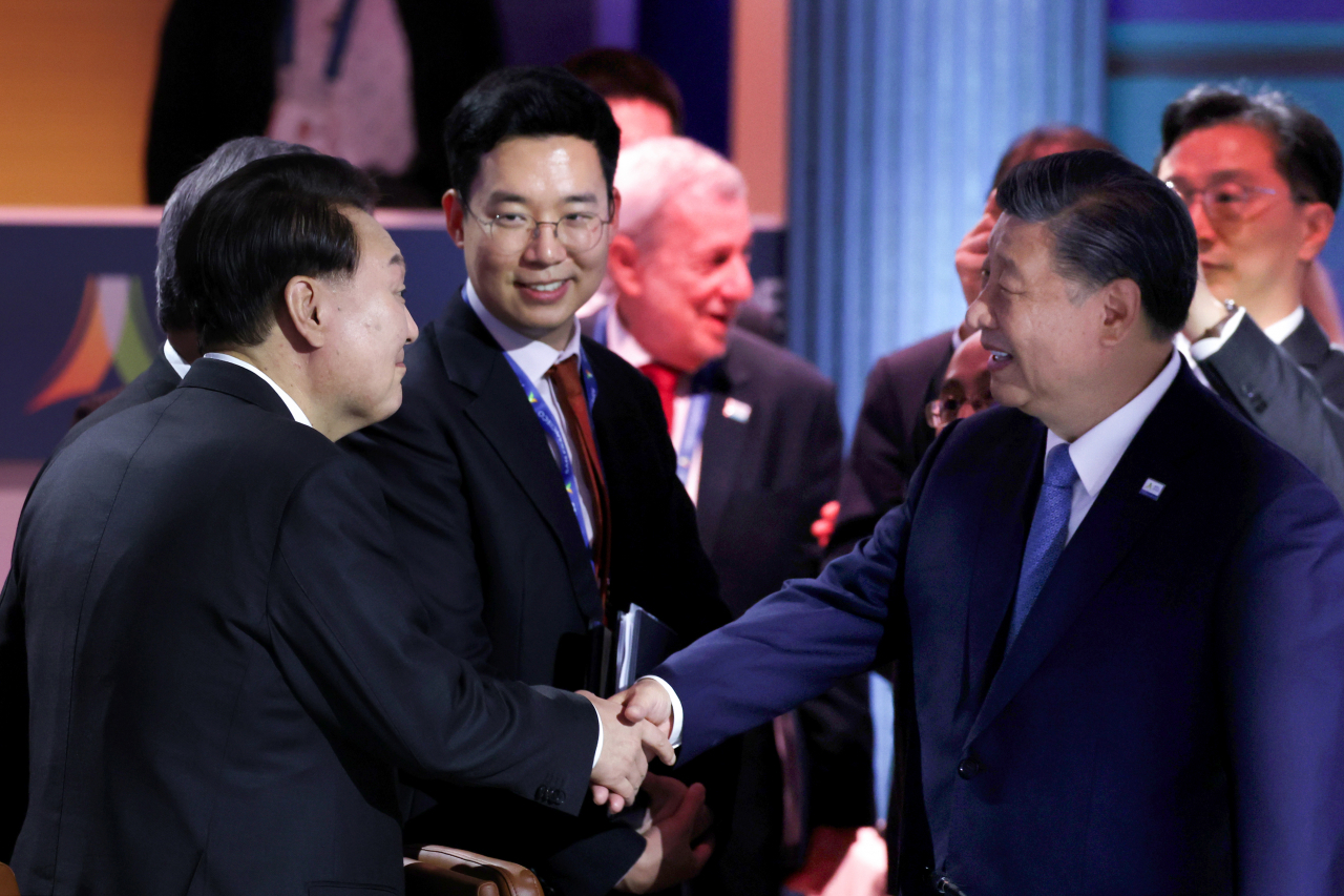 President Yoon Suk Yeol (left) shakes hand with Chinese President Xi Jinping during the APEC leaders' week in San Francisco on Thursday. (Yonhap)