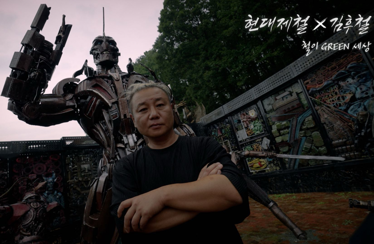A screenshot from the campaign's collaboration video shows scrap metal artist Kim Hoo-cheol standing in front of his robot sculpture, named G-Robot, composed of recycled steel parts. (Hyundai Steel)