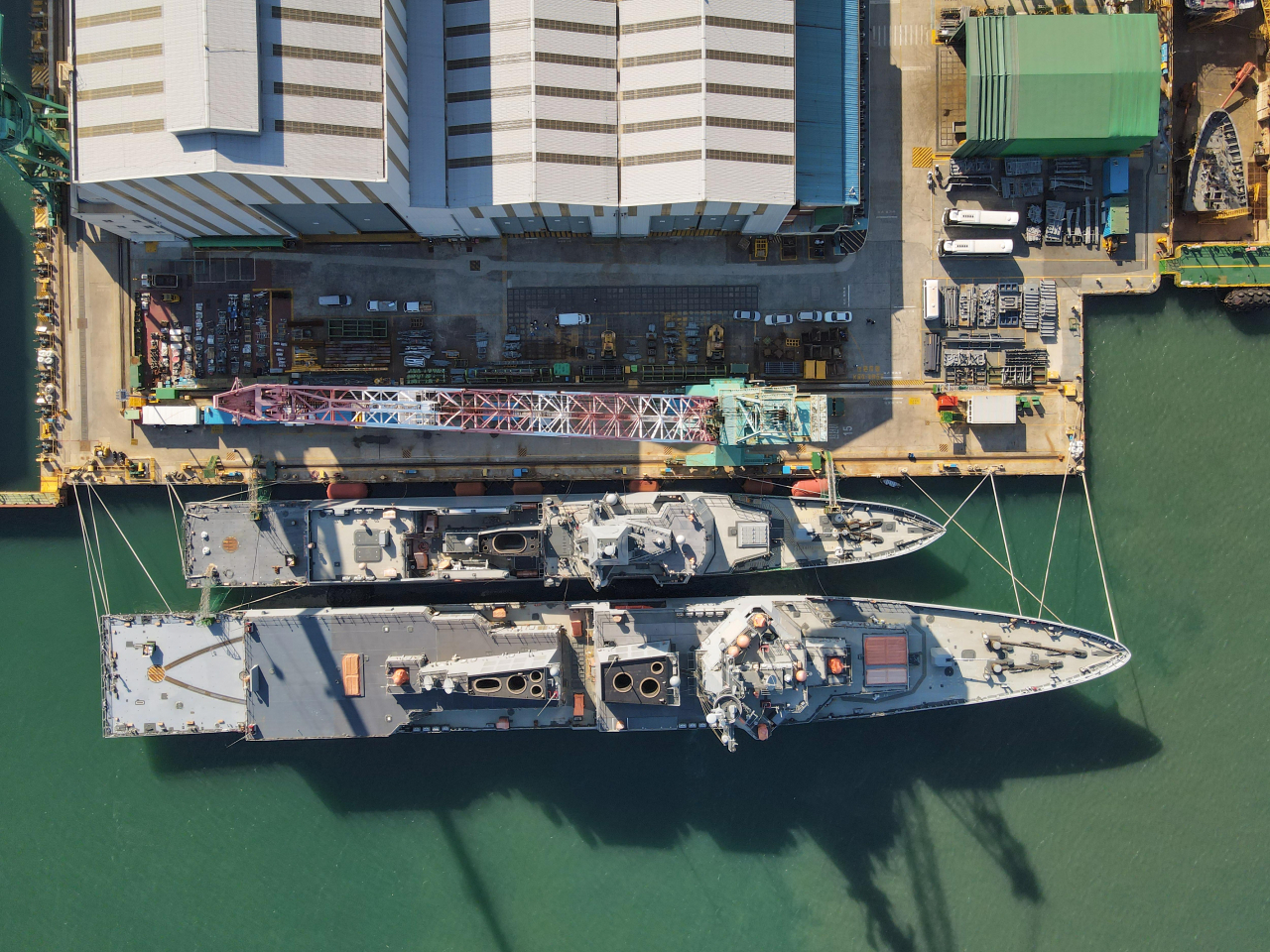 South Korean Navy's Jeongjo the Great (Bottom), an Aegis-equipped destroyer, and Chungnam frigate are tied to a pier at HD Hyundai Heavy Industries' Ulsan shipyard on Monday. (HD Hyundai)