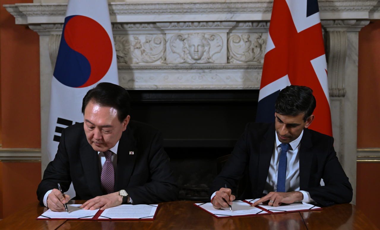 President Yoon Suk Yeol (left) and UK Prime Minister Rishi Sunak sign Downing Street Accord at 10 Downing Street, a UK Prime Minister's office, on Wednesday. (Yonhap)
