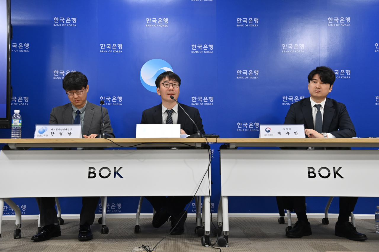 Ahn Byung-nam, head of digital asset research team at the FSS, Kim Dong-sup, head of the digital currency strategy team at the BOK and Bae Su-am, an official in the financial policy division at the FSC speak at a press briefing held at the central bank's headquarters in Seoul, Thursday. (Yonhap)