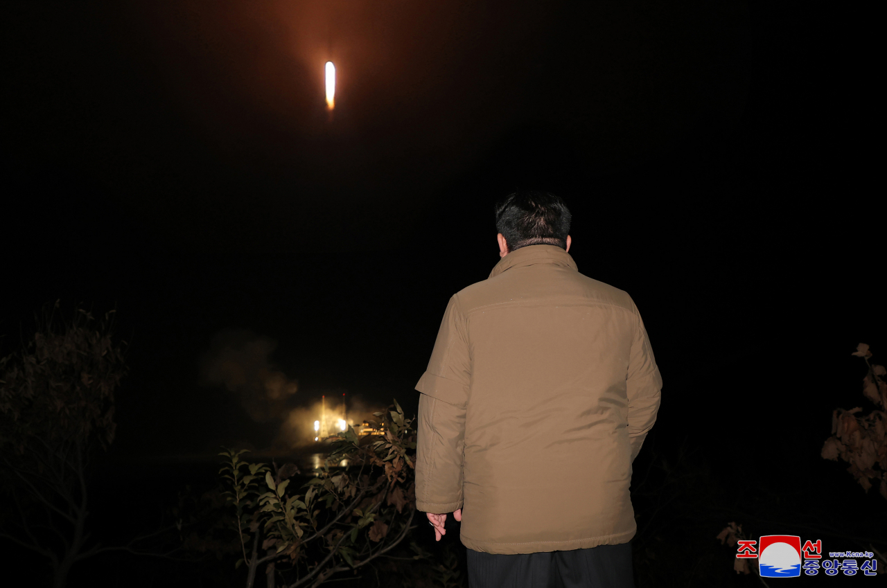 North Korean leader Kim Jong-un watches a new type of Chollima-1 rocket carrying a reconnaissance satellite called the Malligyong-1 being launched from the Sohae satellite launch site in Tongchang-ri in northwestern North Korea at 10:42 p.m. on Tuesday in this photo released the next day by the North's official Korean Central News Agency. (Yonhap)