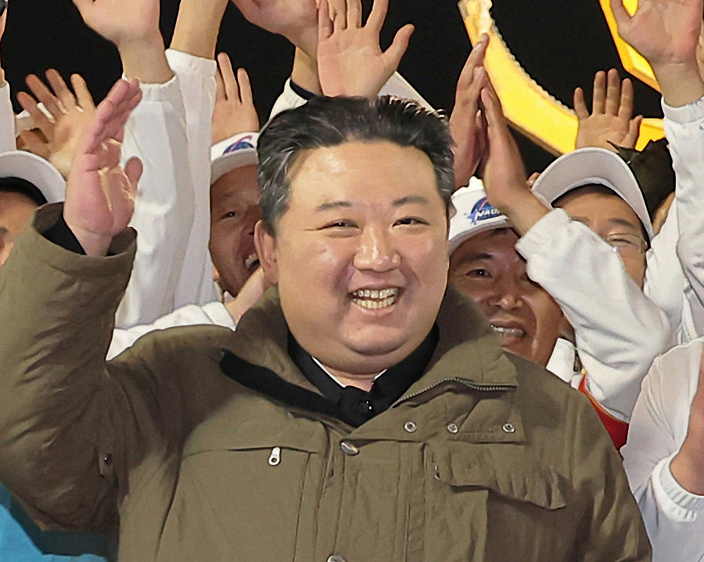 North's leader Kim Jong-un and scientists expressing joy at the North's successful launch of a military spy satellite on Tuesday. (KCNA)