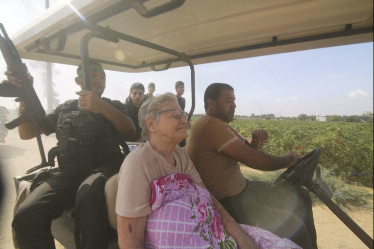 In this still image taken from video, Hamas' militants transport Yaffa Adar, 85, an Israeli civilian kidnapped from Nir Oz, into Gaza strip in a golf cart, in an unspecified location between Israel and Gaza, on Saturday Oct. 7, 2023. Yaffa Adar was among those released Friday, Nov. 24. (AP-Yonhap)