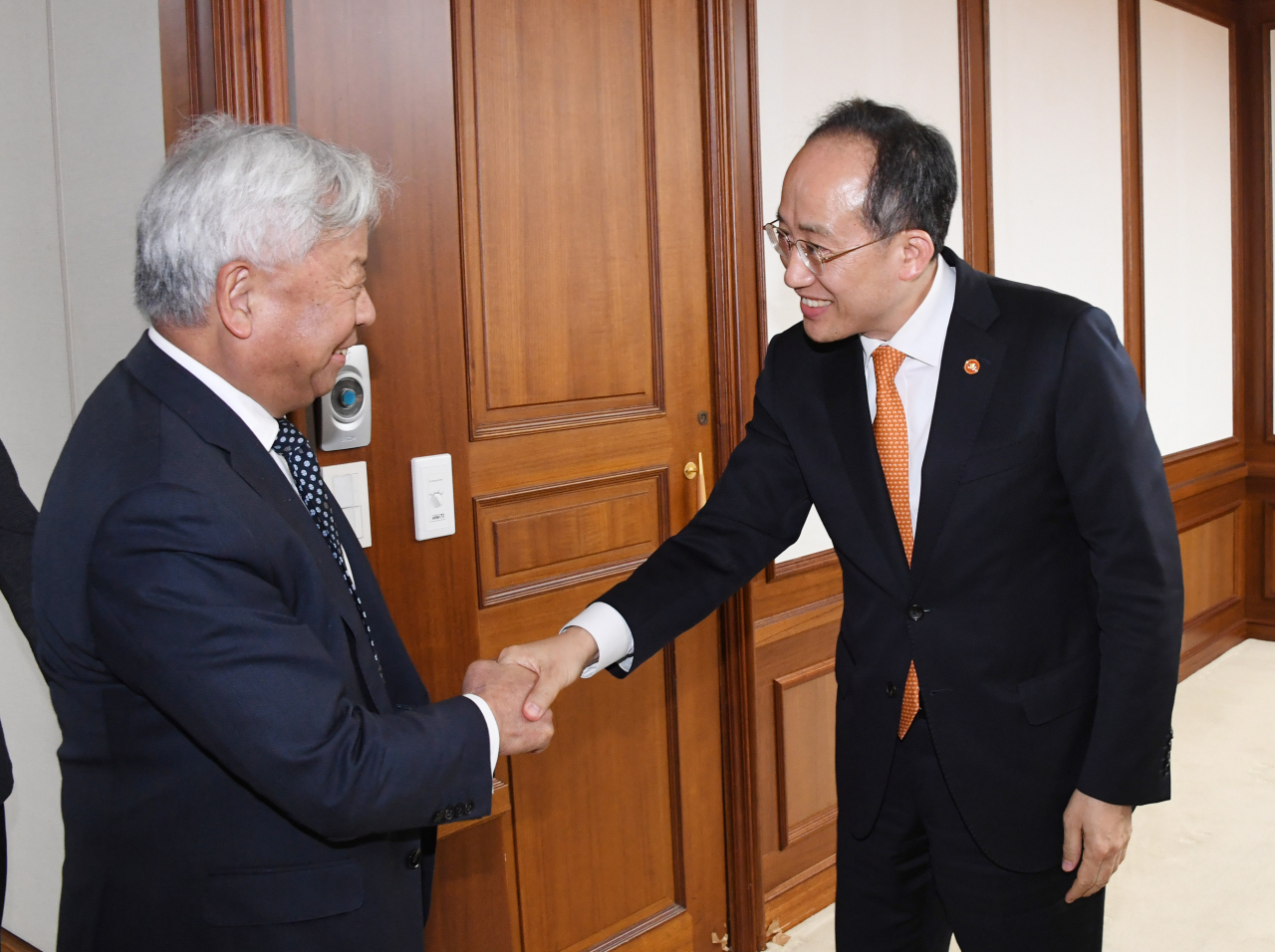 Finance Minister Choo Kyung-ho (right) shakes hands with AIIB President Jin Liqun ahead of their meeting held in Seoul on Monday. (Yonhap)