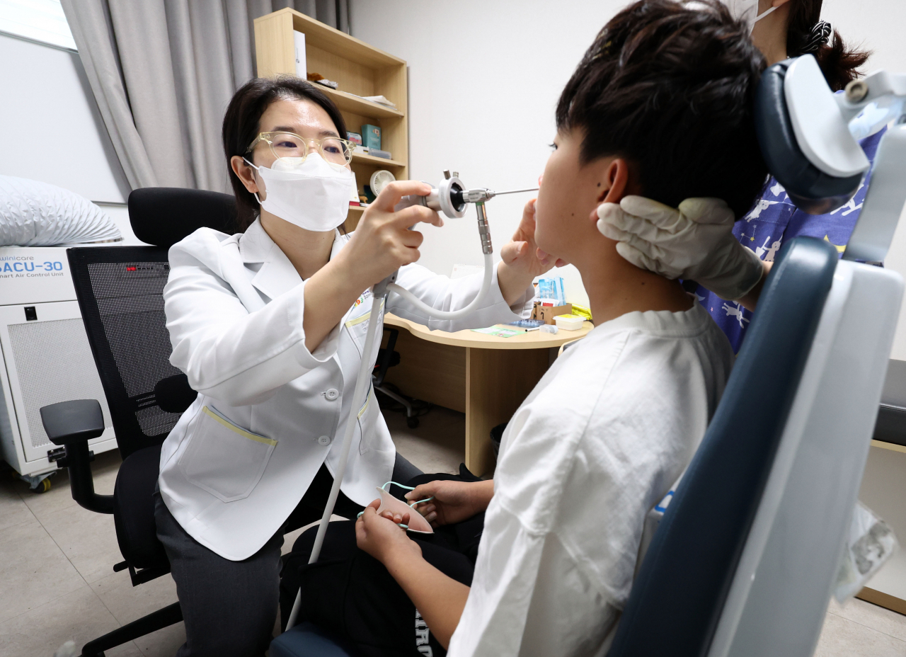 A pediatrician examines a boy at a children's hospital in Seoul's Seongbuk-gu on Oct. 30. This image is not directly related to the story. (Yonhap)