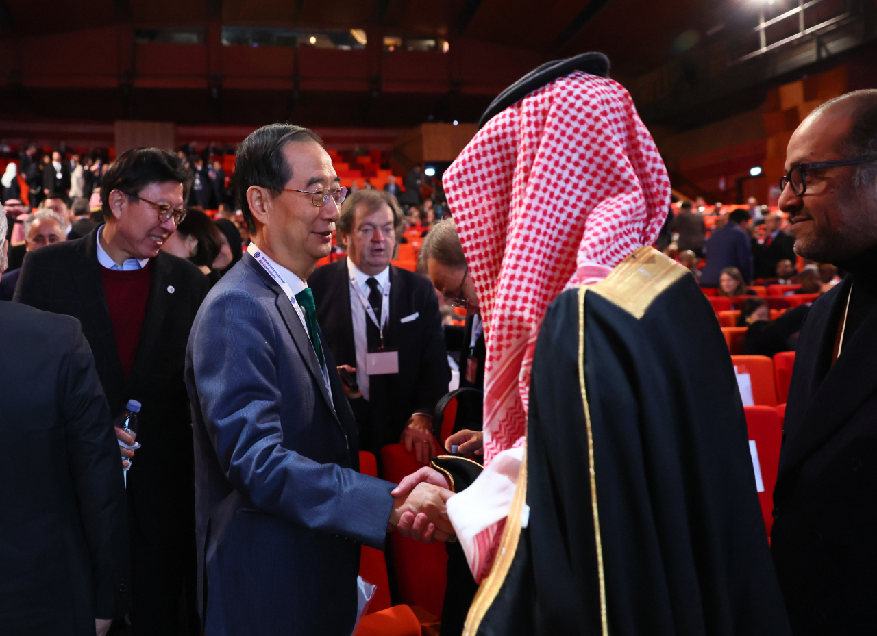 Prime Minister Han Duck-soo (second from left) shakes hand with Saudi Arabia's unnamed government official after the final presentation during the general assembly of the Bureau International des Expositions on Tuesday. (Yonhap)