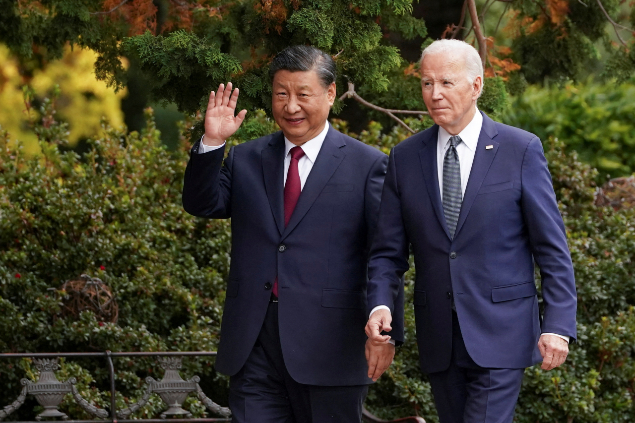 Chinese President Xi Jinping waves as he walks with US President Joe Biden at Filoli estate on the sidelines of the Asia-Pacific Economic Cooperation summit, in Woodside, California, US, Nov.15. (Reuters-Yonhap)