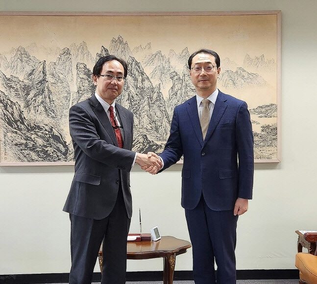 Kim Gunn, Korea's special representative for Korean Peninsula peace and security affairs (left), shakes hands with senior Japanese diplomat Hiroyuki Namazu, Tuesday. (The Ministry of Foreign Affairs)