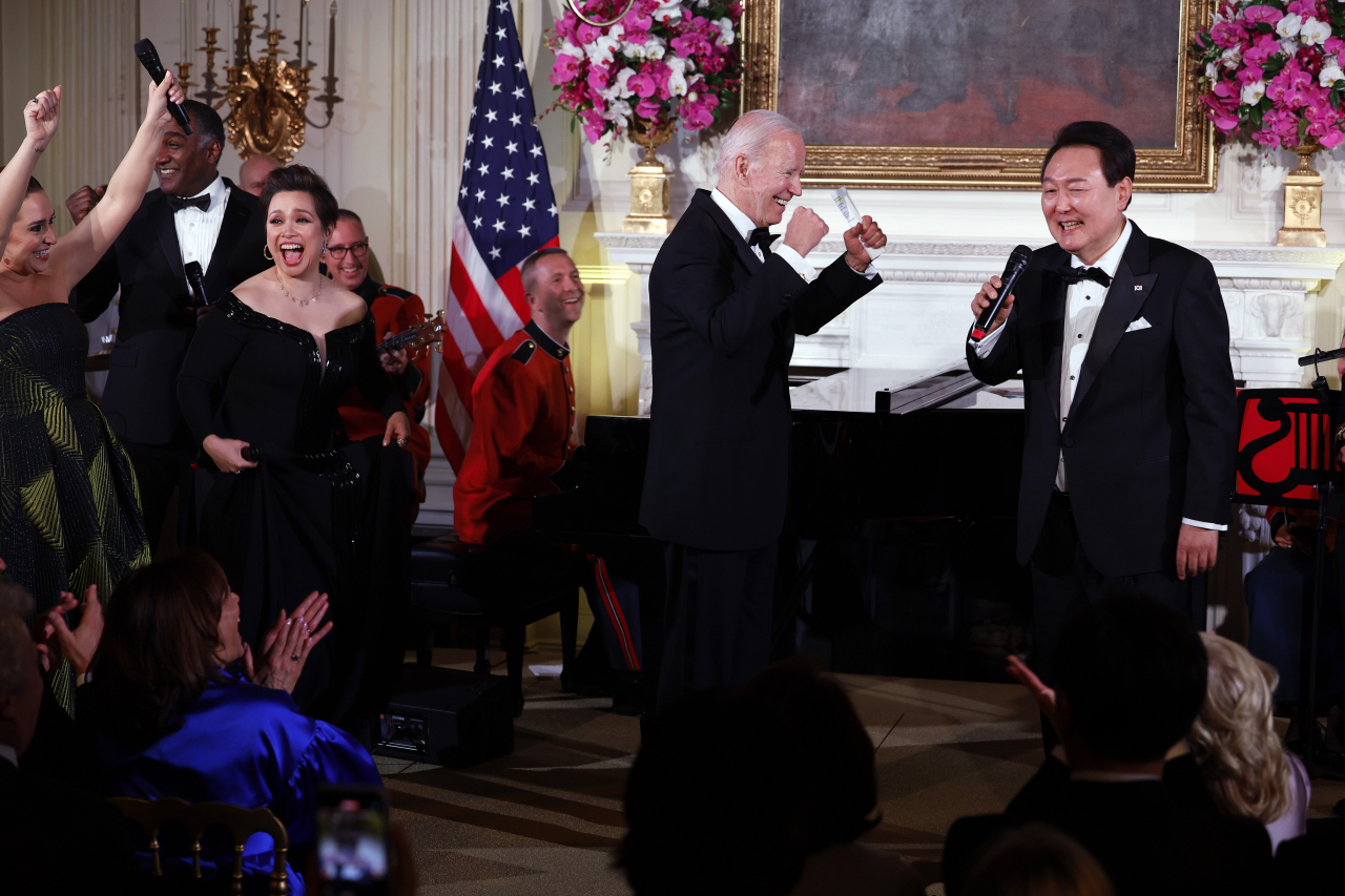 US President Joe Biden cheers as South Korean President Yoon Suk Yeol sings 