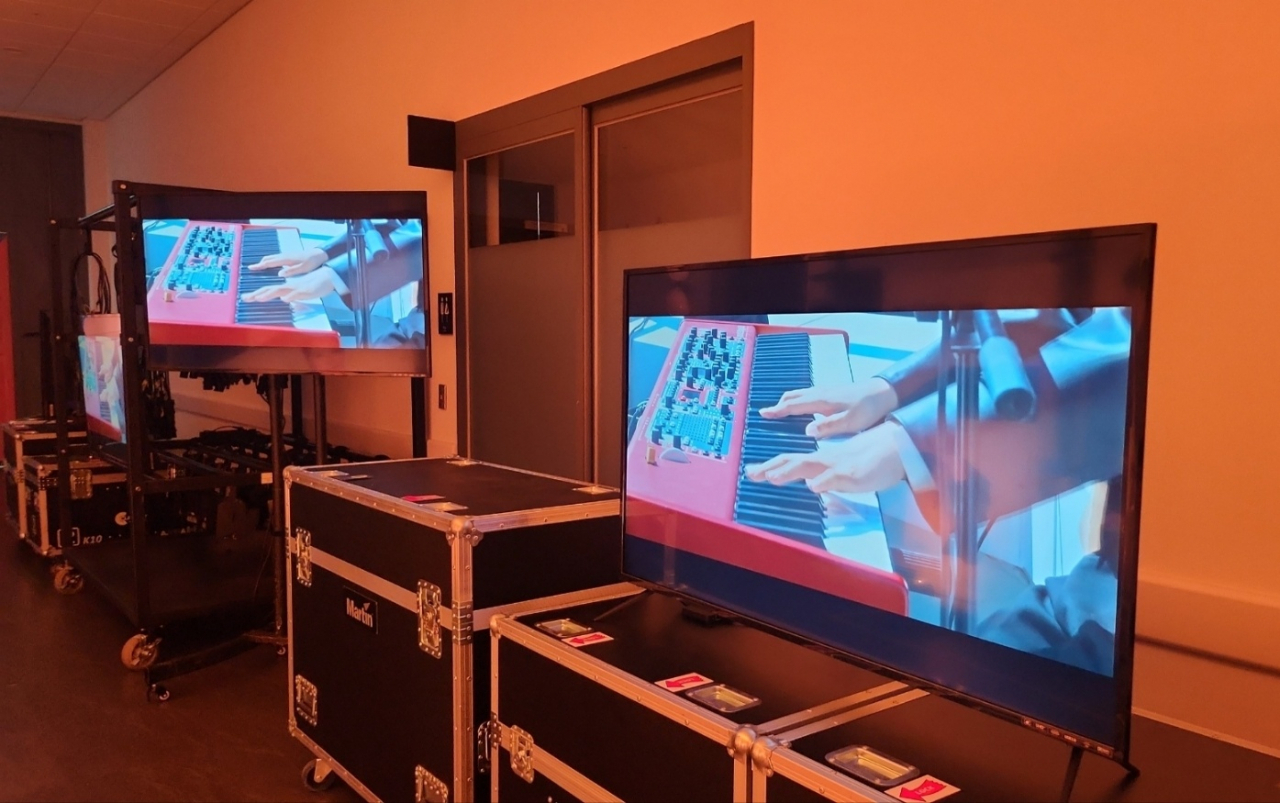 Videos of six Antenna artists play on screens in the hallway of the backstage area, Wednesday. (Lee Jung-youn/The Korea Herald)