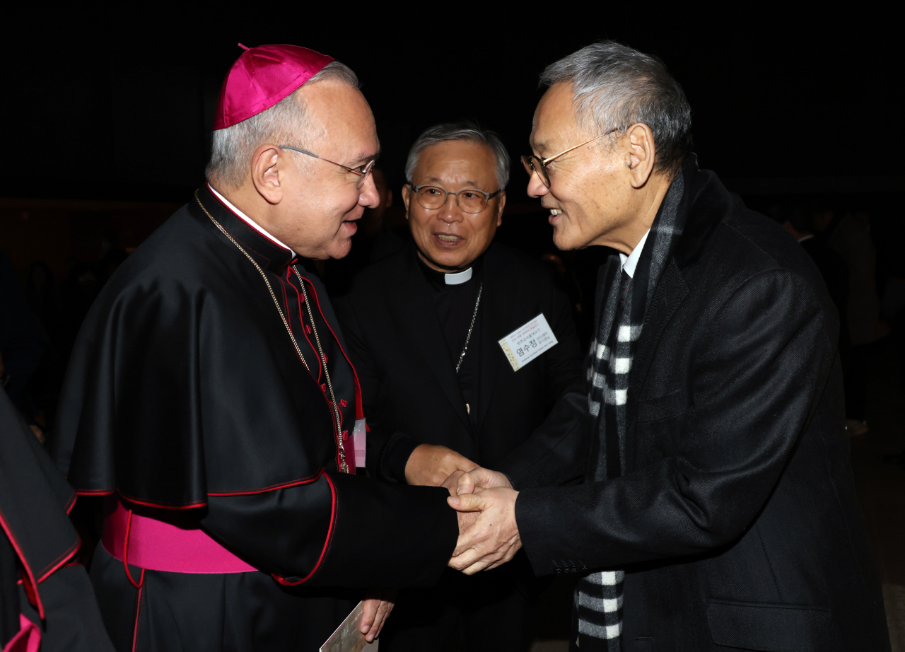 South Korean Culture Minister Yu In-chon (right) greets Archbishop Edgar Pena Parra, substitute for the Vatican's secretariat of state, at an exhibition celebrating the 60th anniversary of South Korea-Vatican diplomatic relations in Seoul on Nov. 17. (Yonhap)