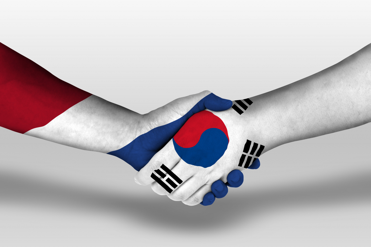 The national flags of the Netherlands (left) and South Korea are embedded within images of shaking hands. (123rf)