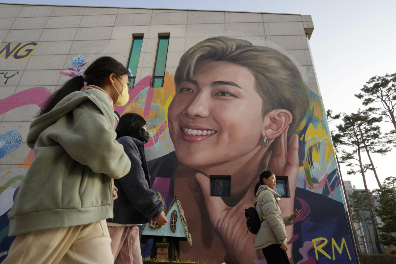 People walk by a mural depicting RM, a member of South Korean K-pop band BTS, in Goyang, South Korea, Sunday. (AP-Yonhap)