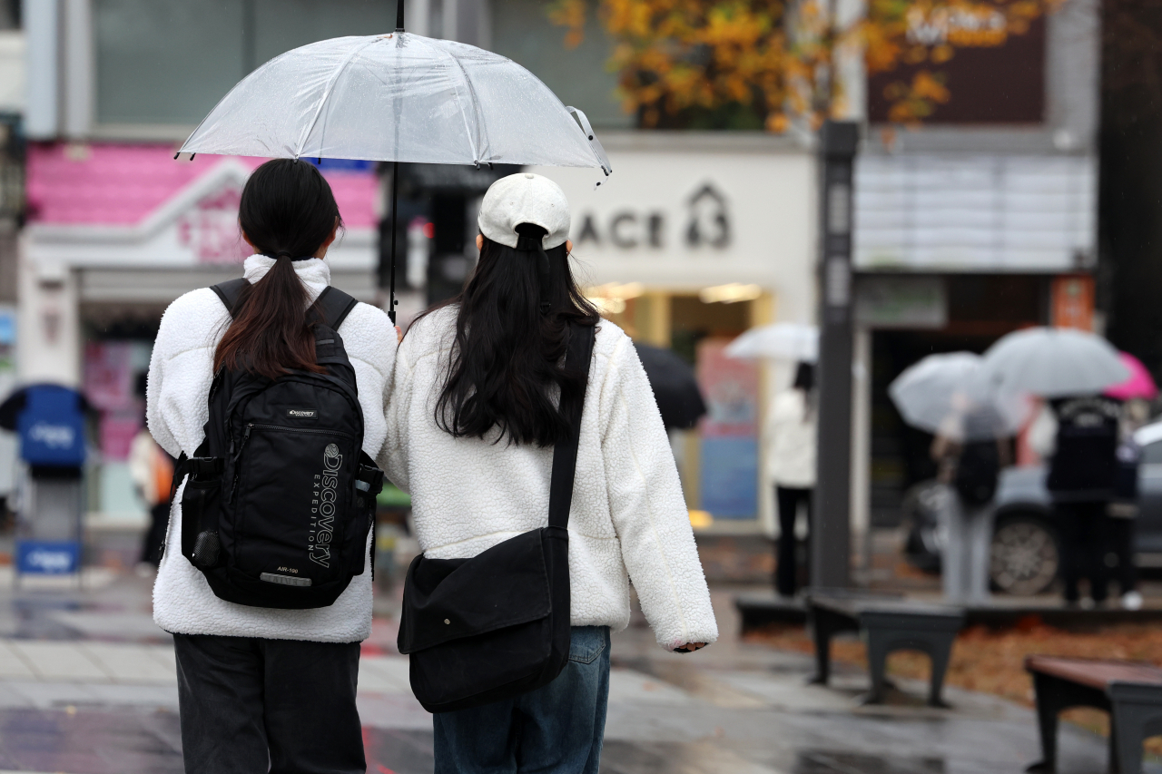 Pedestrians share an umbrella while walking through the rain in Gwangju, Monday. (Yonhap)