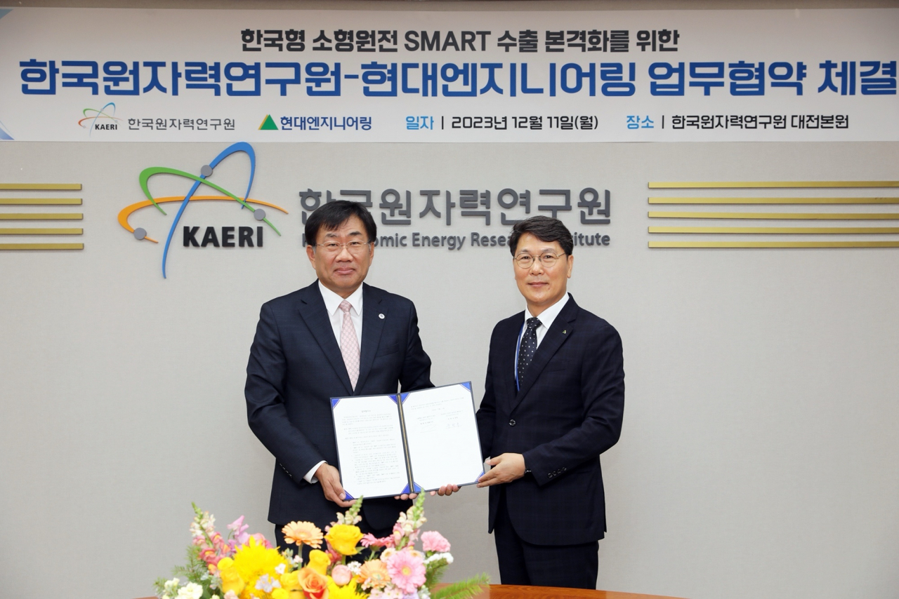 Hyundai Engineering CEO Hong Hyeon-sung (left) and Korea Atomic Energy Research Institute President Joo Han-gyu pose for a photo during a signing ceremony held at KAERI's Daejeon headquarters on Monday. (Hyundai Engineering)