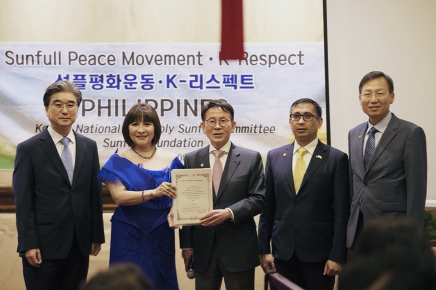 Chair Min Byoung-chul of Sunfull Foundation (center) presents signed pledges to Philippine Congress Rep. Marissa 