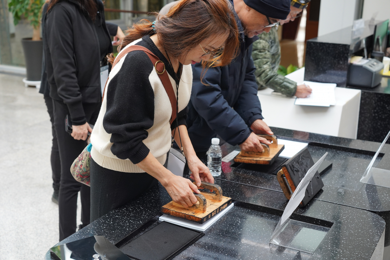 Visitors try ink printing at the Gosan Yunseondo Museum on Dec. 9. (Lee Si-jin/The Korea Herald)