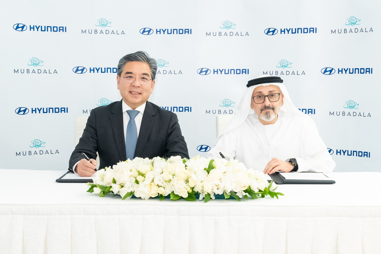 Chang Jae-hoon (left), president and CEO of Hyundai Motor Co., and Waleed Al Mokarrab Al Muhairi, the deputy group CEO of the Investment Committee at Mubadala Development Co., pose for a photo at the signing ceremony held in Abu Dhabi's Mubadala Tower on Friday. (Hyundai Motor Group)