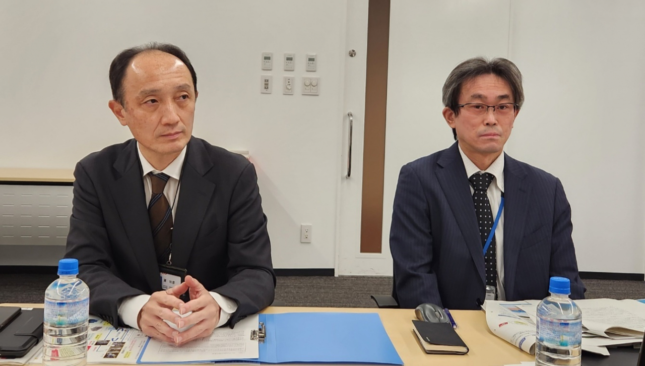 Tomohiko Mayuzumi, risk communicator at Tepco’s Corporate Communications Office, and Hiroaki Ishibashi, manager at the same office, speak during an interview with reporters at Tepco headquarters in Tokyo on Dec. 1. (Joint Press Corps)