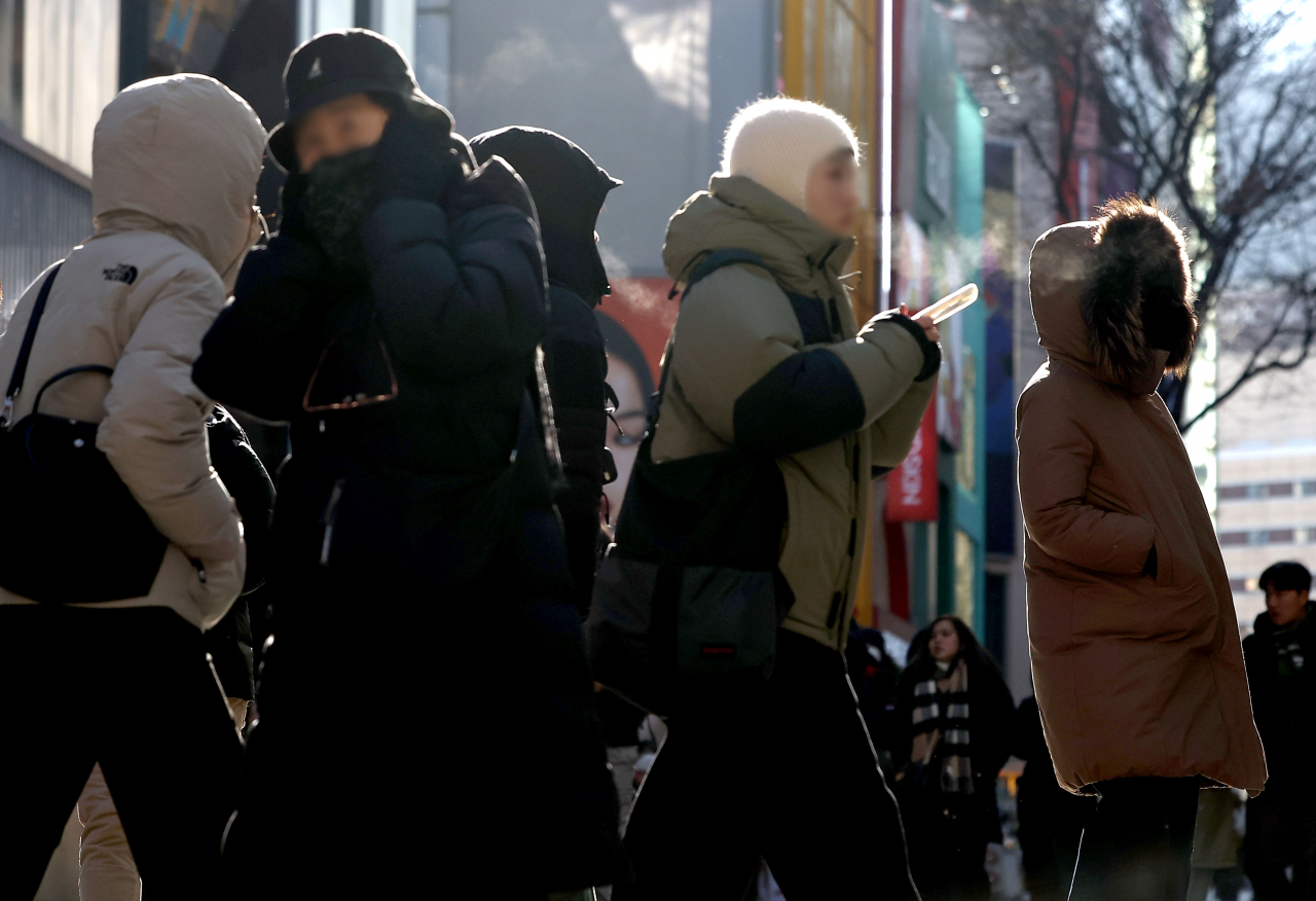 People walk in Seoul's central shopping area of Myeongdong amid the season's strongest cold wave on Sunday. (Yonhap)