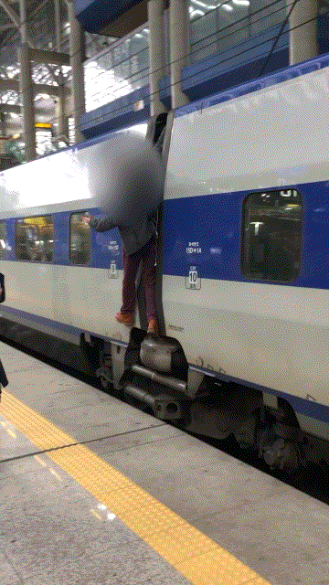 A man hangs on the outside of a KTX train, which departed from a platform of Gwangmyeong Station in Gyeonggi Province on Friday. (YouTube)