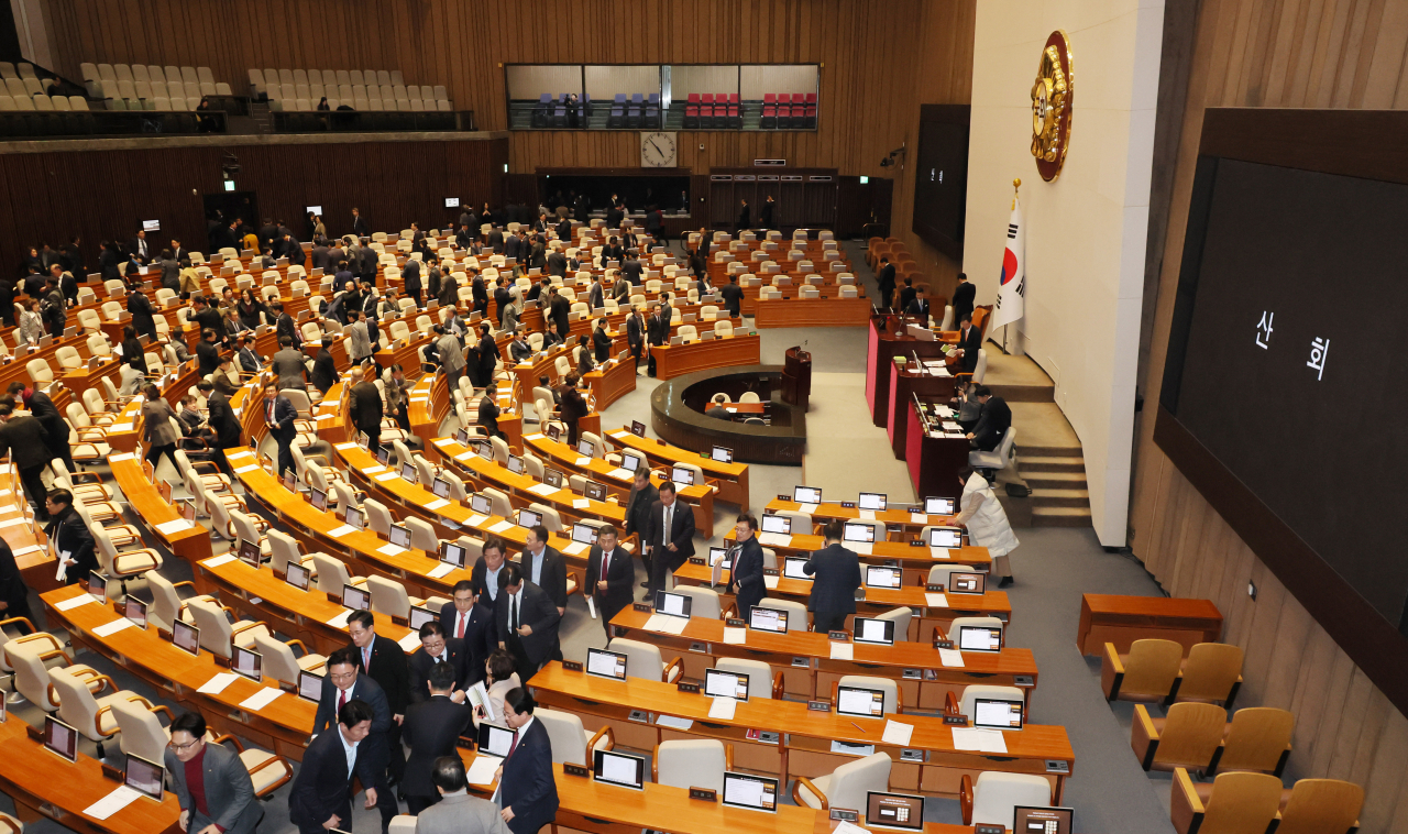 Lawmakers leave the main hall at the National Assembly after passing the government budget for next year, Thursday. (Yonhap)