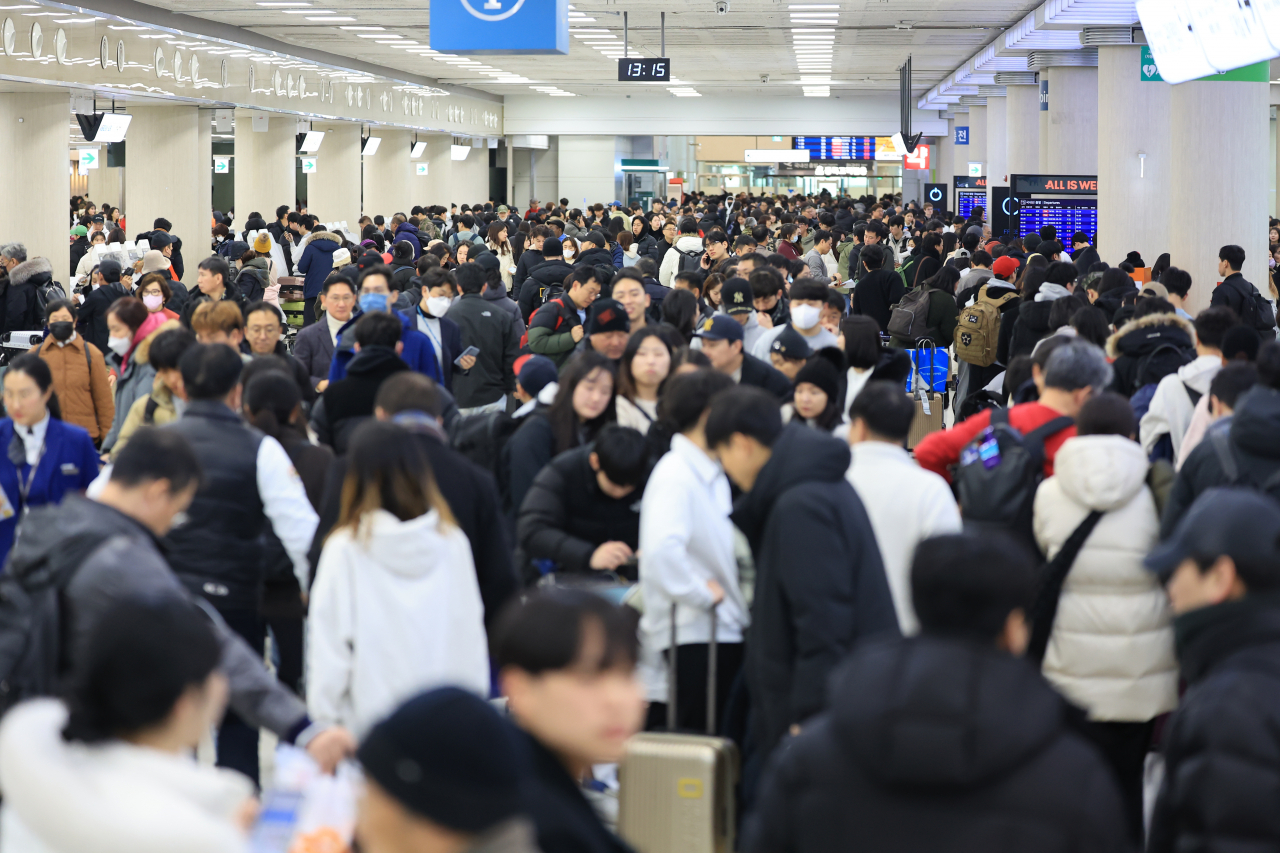 The departure area for domestic flights at Jeju International Airport is crowded with passengers after heavy snowfall suspended or delayed all flights. (Yonhap)