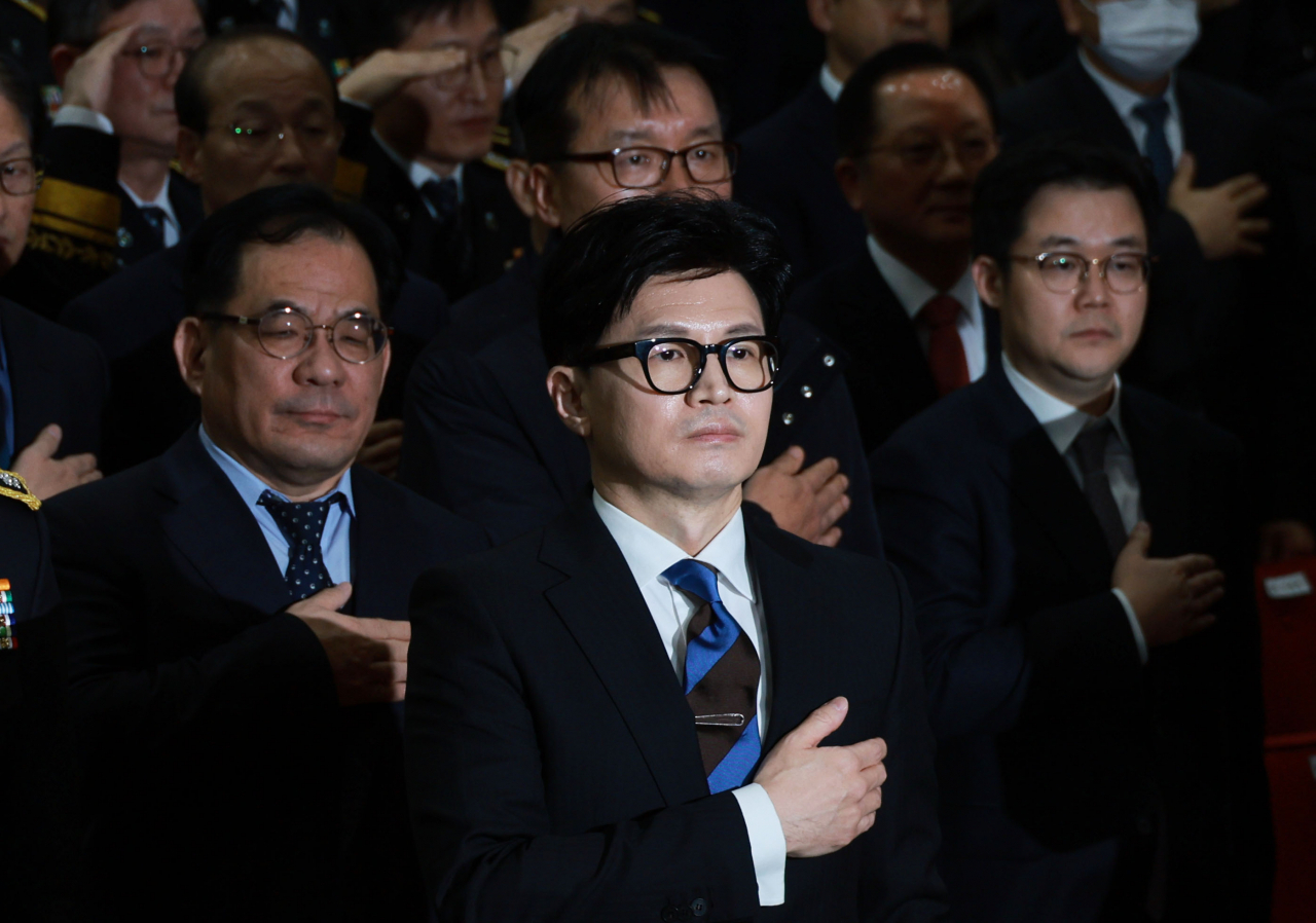 Han Dong-hoon salutes the national flag during a ceremony held at the Justice Ministry headquarters in Gwacheon near Seoul on Thursday. (Yonhap)