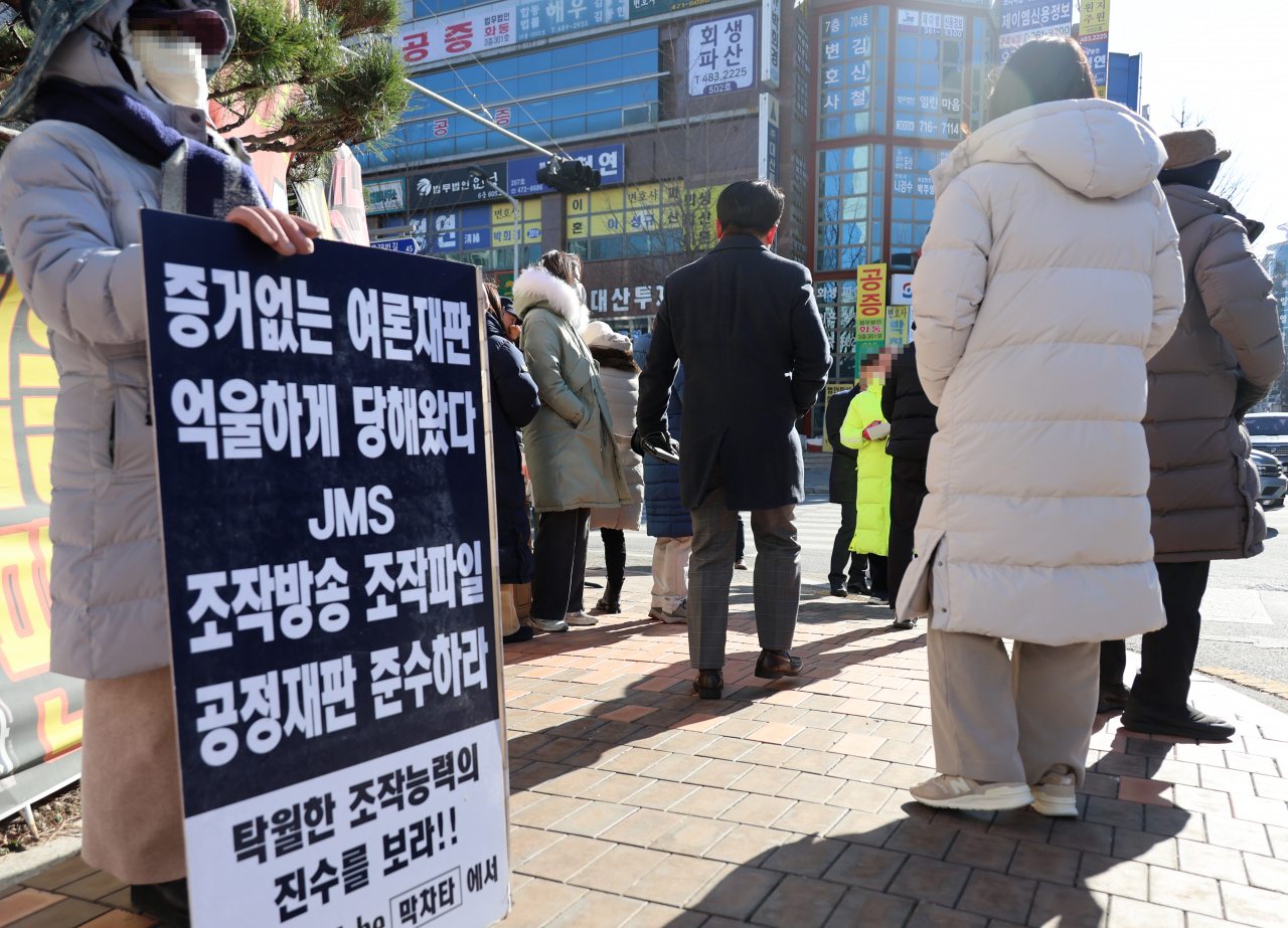 Supporters of Jeong Myeong-seok, the leader of a controversial religious organization, the Jesus Morning Star, wait for a ruling against Jeong outside the Daejeon District Court on Friday. (Yonhap)