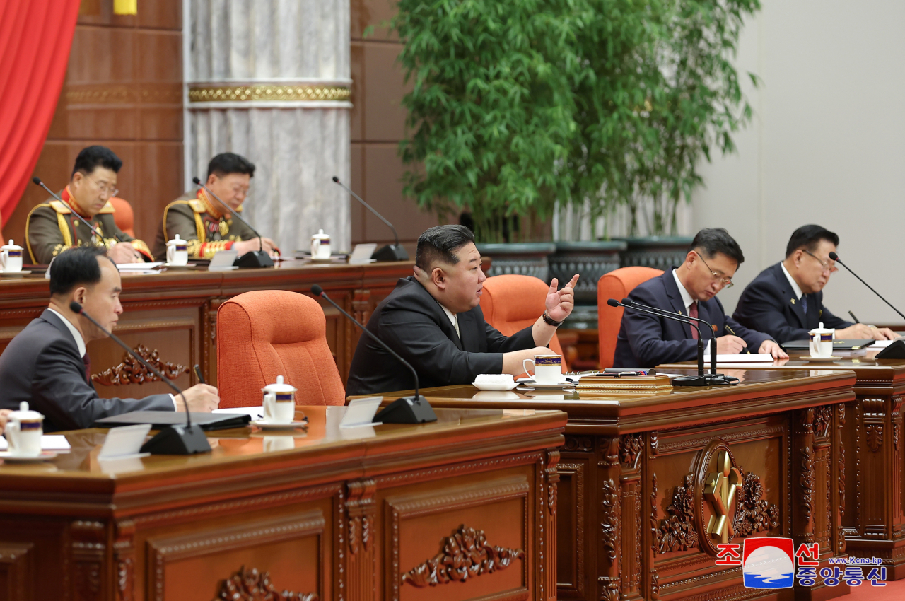 This photo, on Thursday, shows the North's leader Kim Jong-un (left) attending the ninth plenary meeting of the eighth Central Committee of the ruling Workers' Party of Korea the previous day. (KCNA)