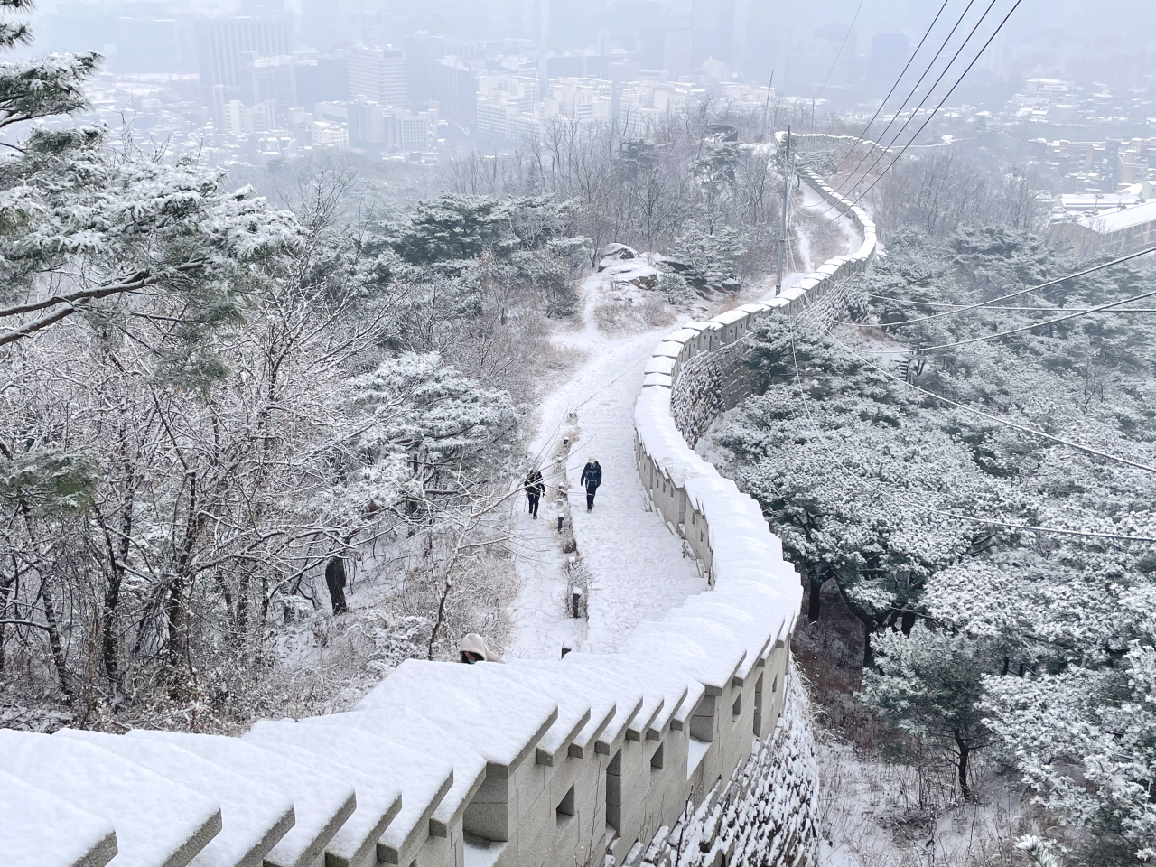This photo shows the Inwangsan Mountain trail covered by snowfall in central Seoul, Monday. (Yonhap)