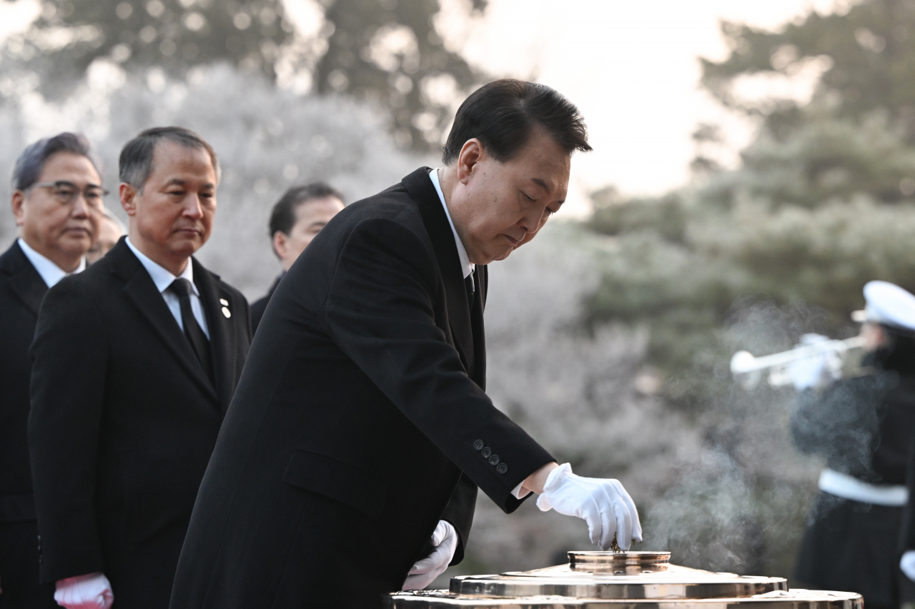 President Yoon Suk Yeol (center) burns incense to pay tribute to the fallen heroes at Seoul National Cemetery on Monday. (Presidential Office)