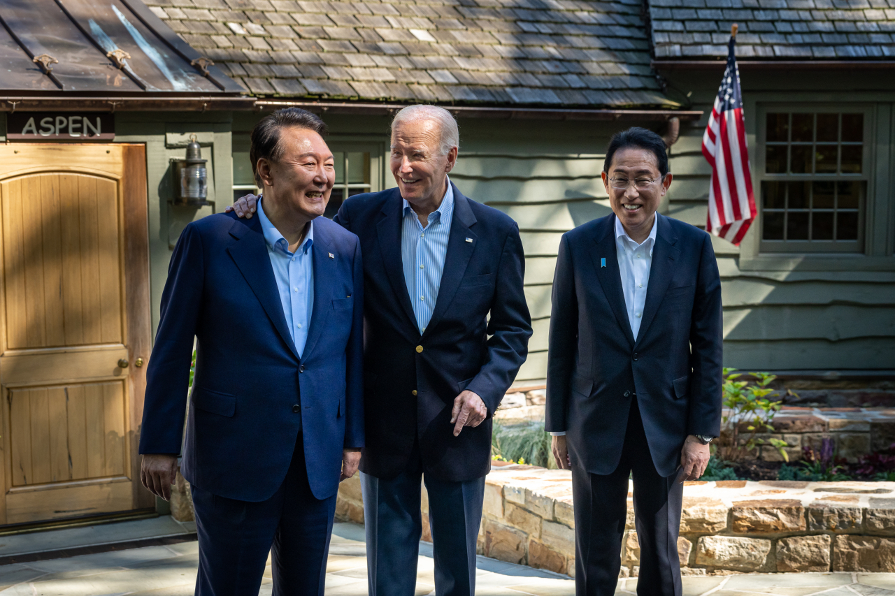 President Joe Biden bids farewell to South Korean President Yoon Suk Yeol (left) and Japanese Prime Minister Fumio Kishida after their trilateral meeting and press conference on Aug. 18, in front of the Aspen Cabin at Camp David, Maryland. (White House)