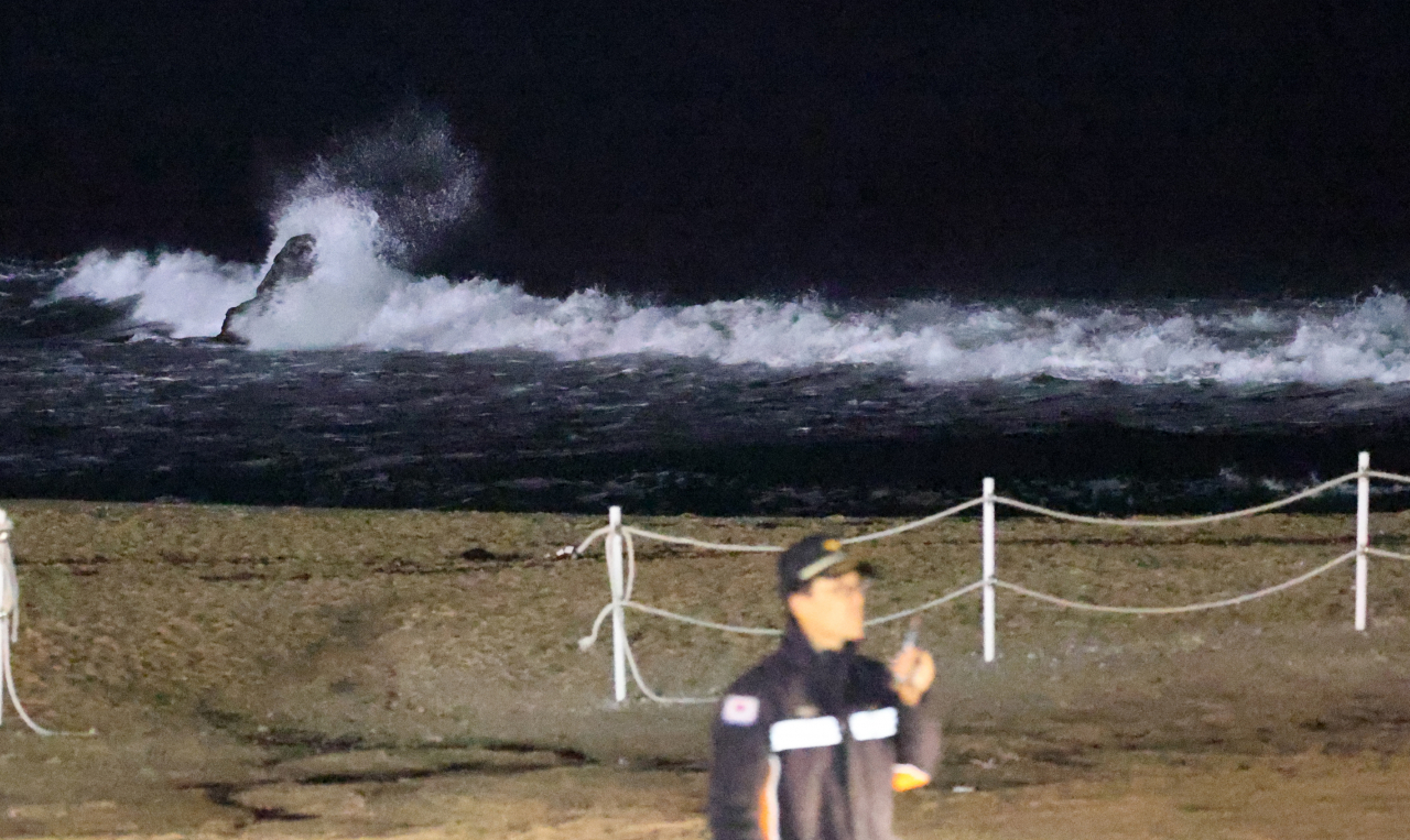 A firefighter in Gangneung, Gangwon Province, inspects a beach by the East Sea on Monday as a major earthquake off Japan's west coast caused minor tsunamis in waters off the South Korean east coast. (Yonhap)