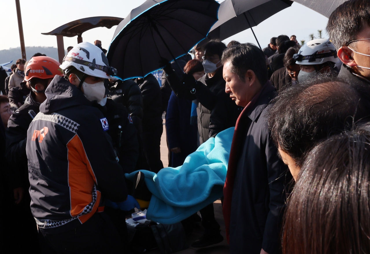 Lee Jae-myung, leader of the main opposition Democratic Party, is being transferred to an ambulance after sustaining an attack by an unidentified person in Busan, Tuesday. (Yonhap)