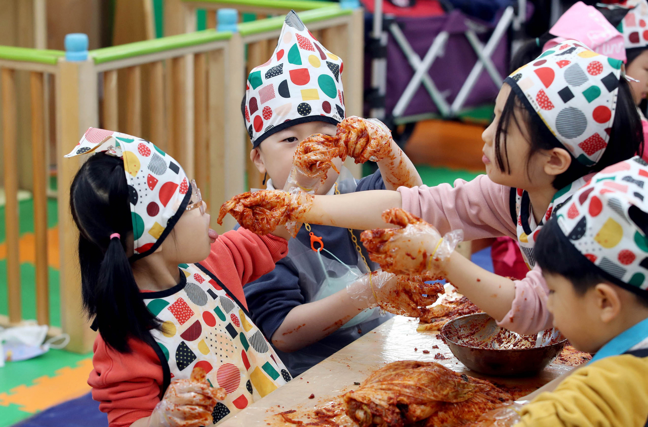 Children participate in a kimchi-making event at a local day care center in Gwangju, Dec. 7. (Yonhap)