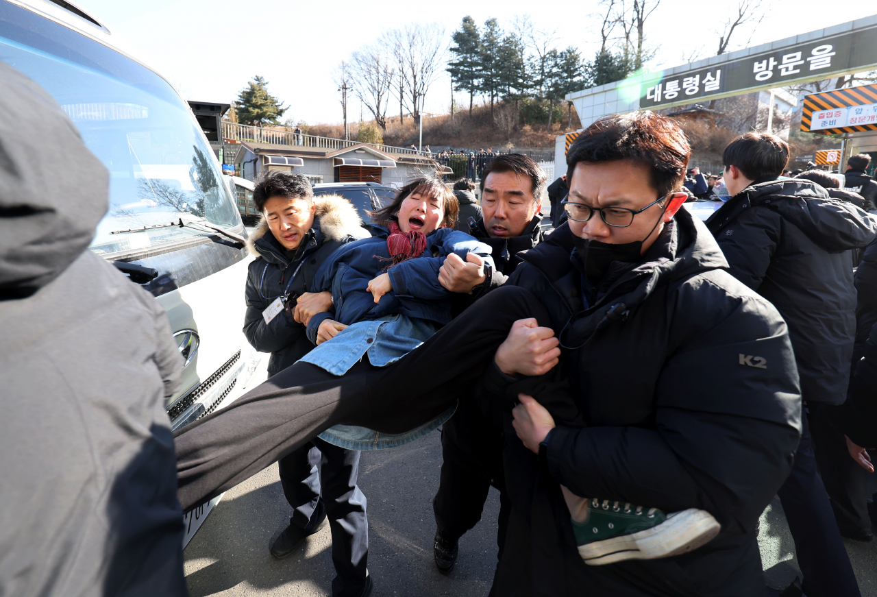 A member of the Korean University Progressive Union is seen being blocked while attempting to force her way into the presidential office grounds in Yongsan-gu, Seoul on Saturday. (Newsis)