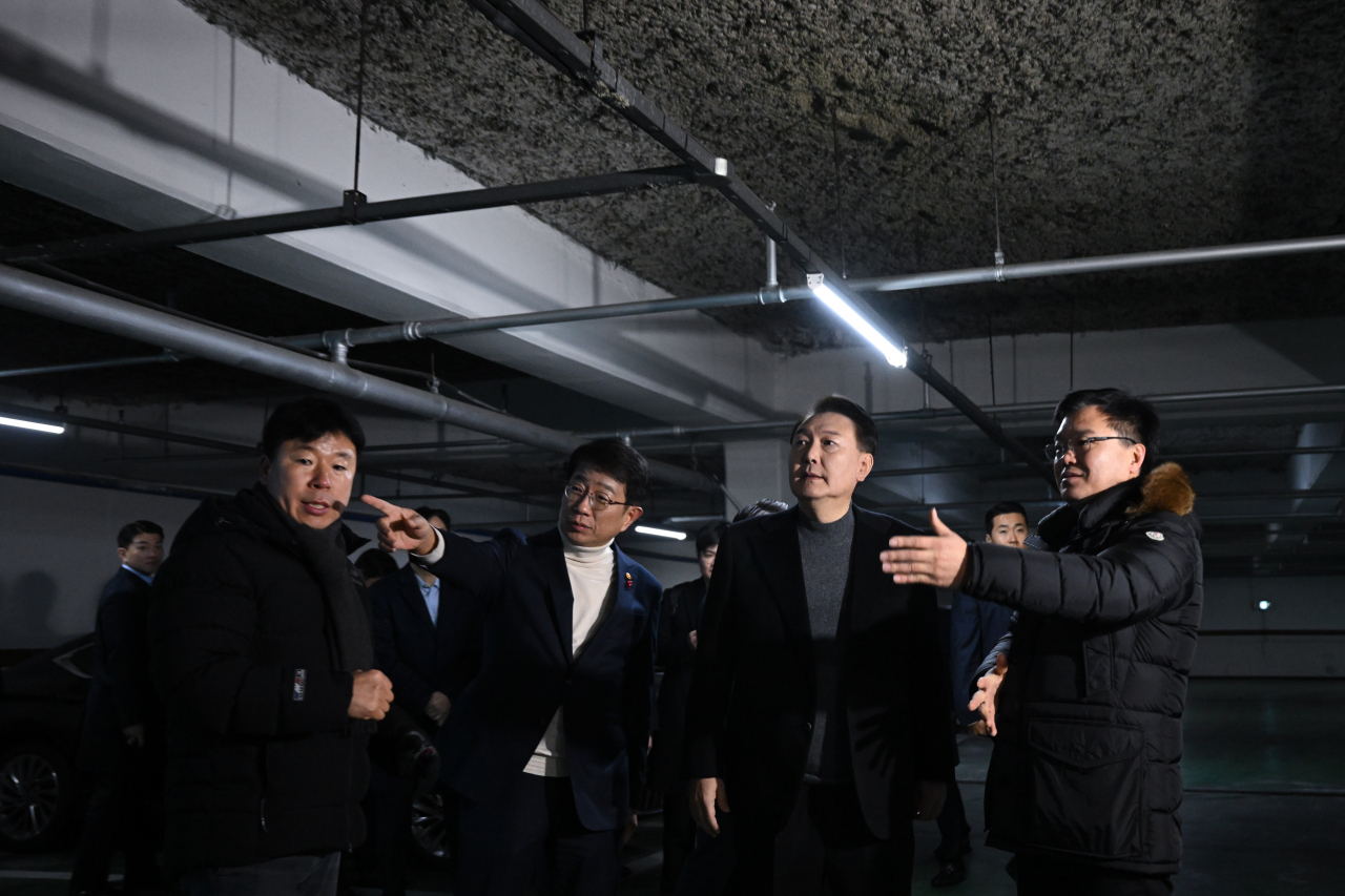 President Yoon Suk Yeol (third from left) on Wednesday inspects a basement parking lot at a residential complex of old apartment buildings in Goyang, Gyeonggi Province. Yoon was briefed about poor living conditions in the apartment building, whose residents' request for reconstruction had been rejected. (Yonhap)
