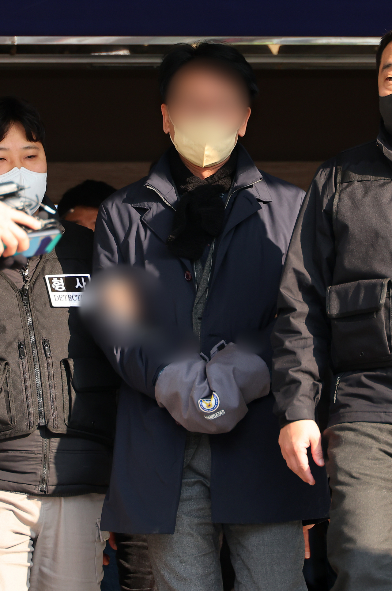 The suspect in the stabbing attack on Lee Jae-myung, leader of the main opposition Democratic Party of Korea, identified by his surname Kim, speaks to reporters in front of Busan Yeonje Police Station as he is being transported to the prosecution, Wednesday. (Yonhap)